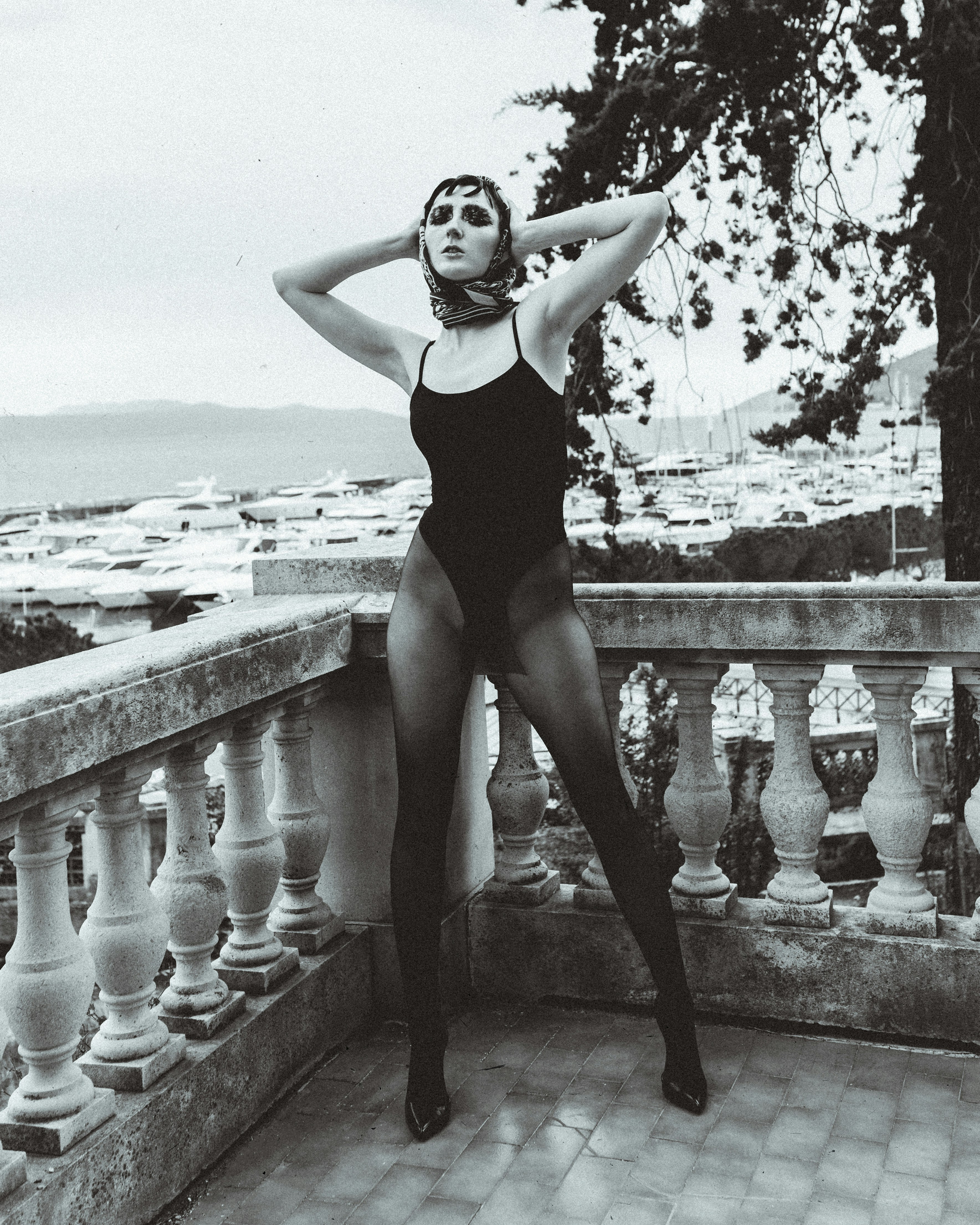 Woman in black one piece swimsuit standing on concrete fence photo ...