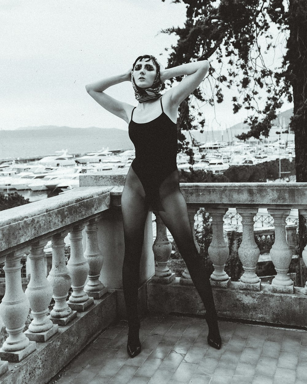 woman in black one piece swimsuit standing on concrete fence