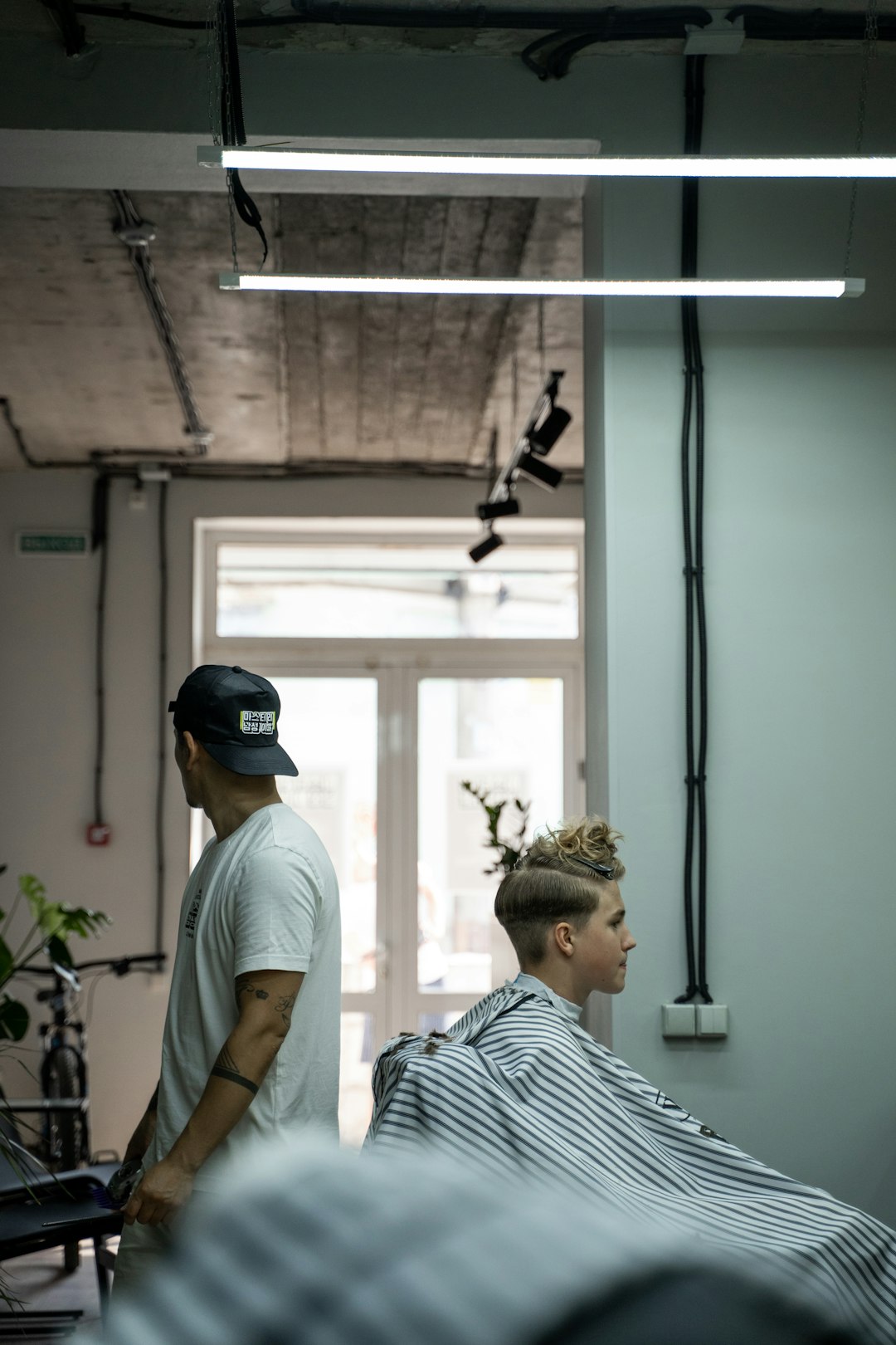 man in white and black stripe shirt wearing black cap