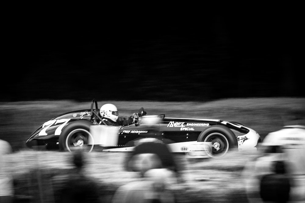 grayscale photo of a man riding a car