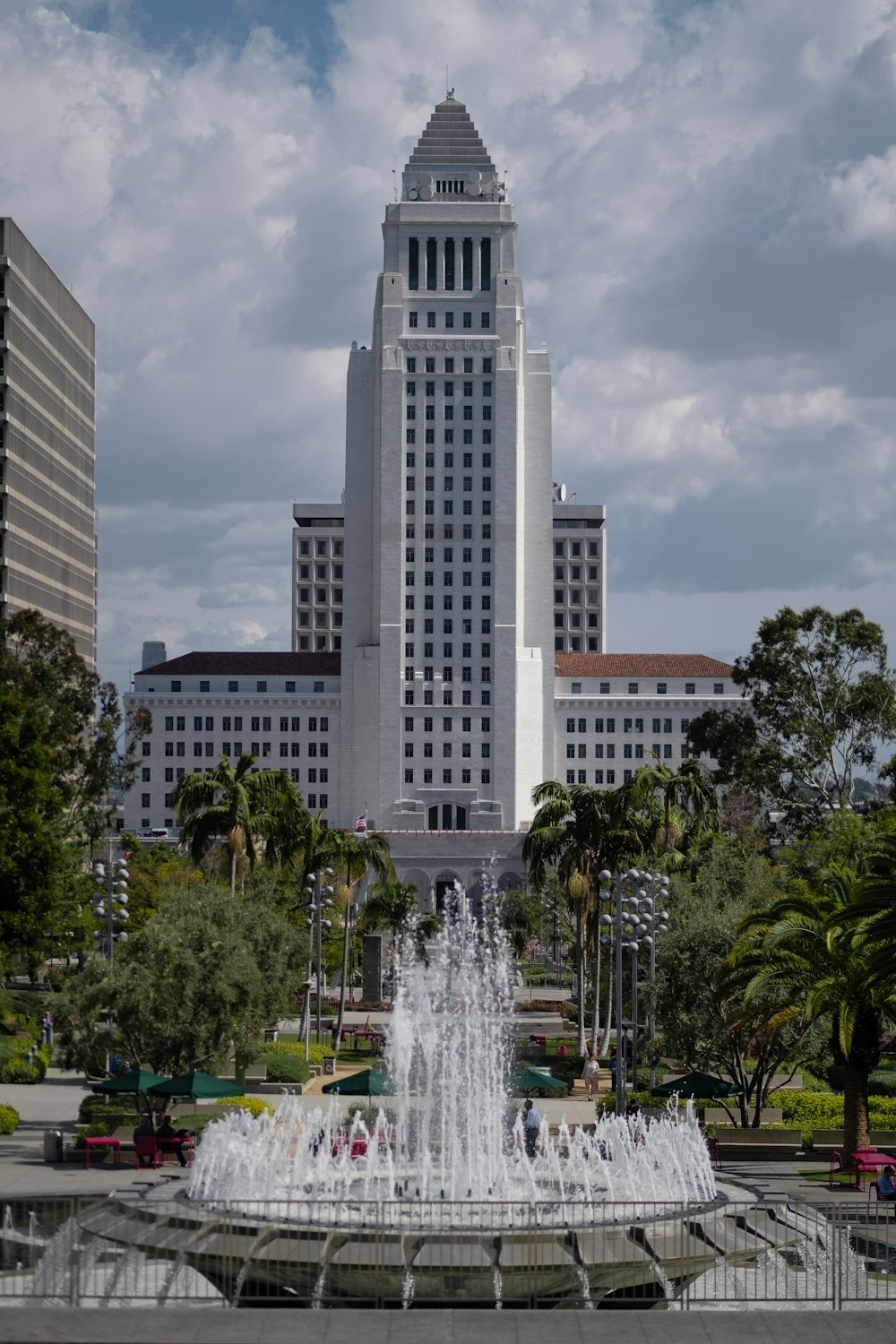 fountain in the middle of trees and buildings during daytime