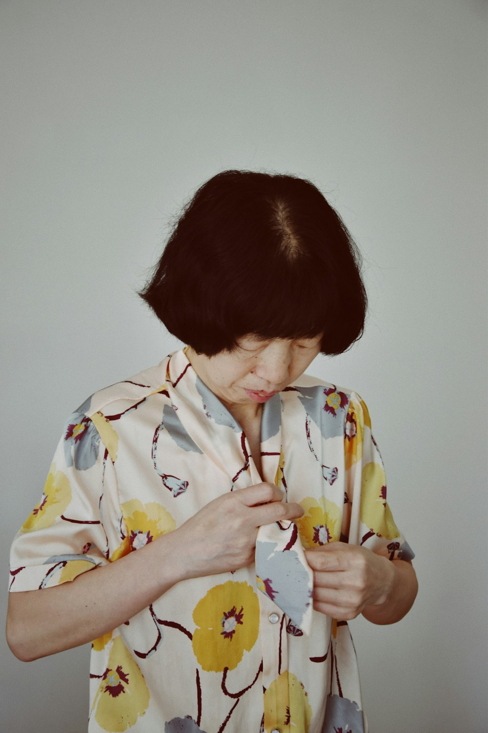 woman in yellow and white floral shirt