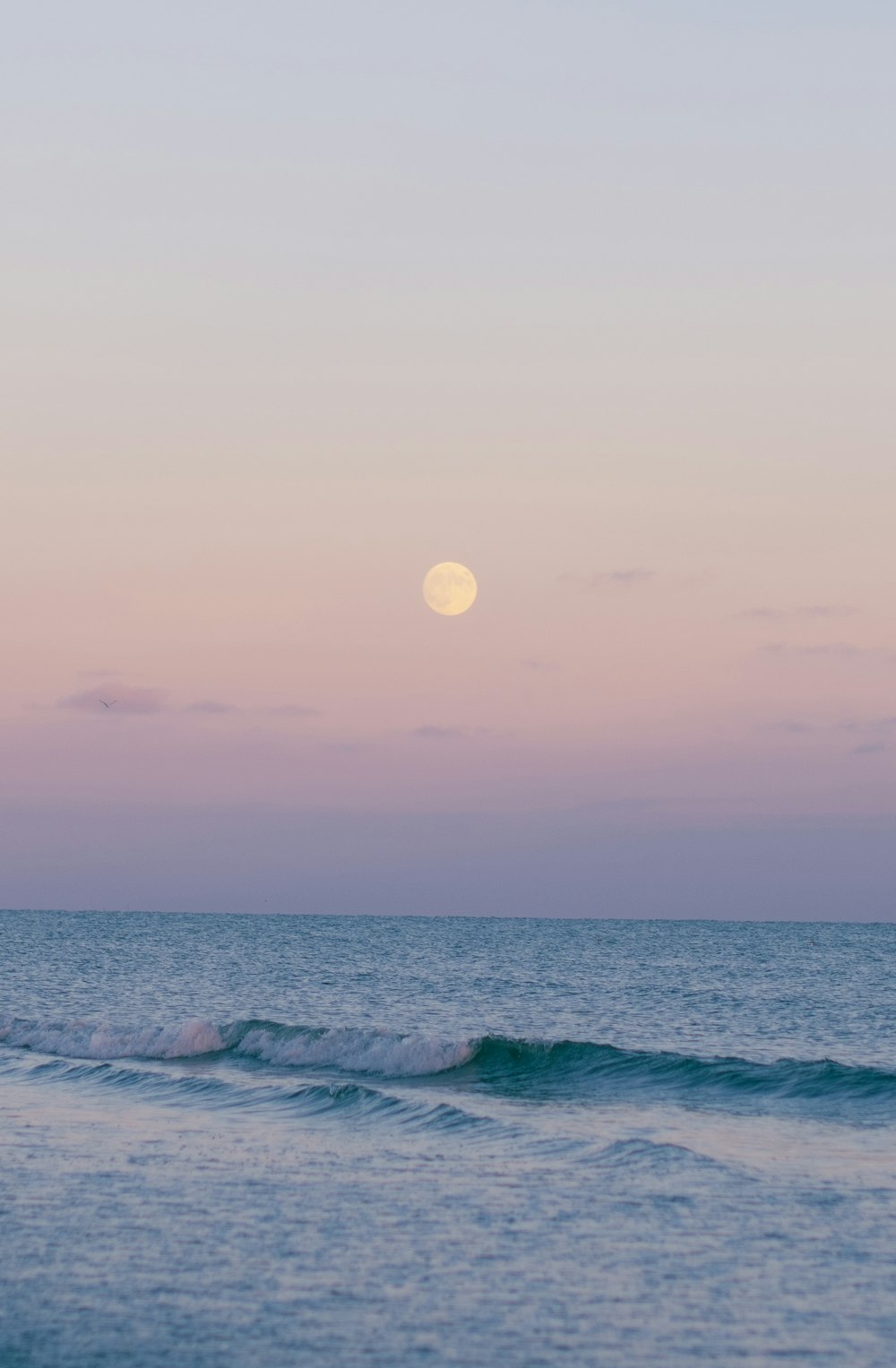 ocean waves crashing on shore during sunset