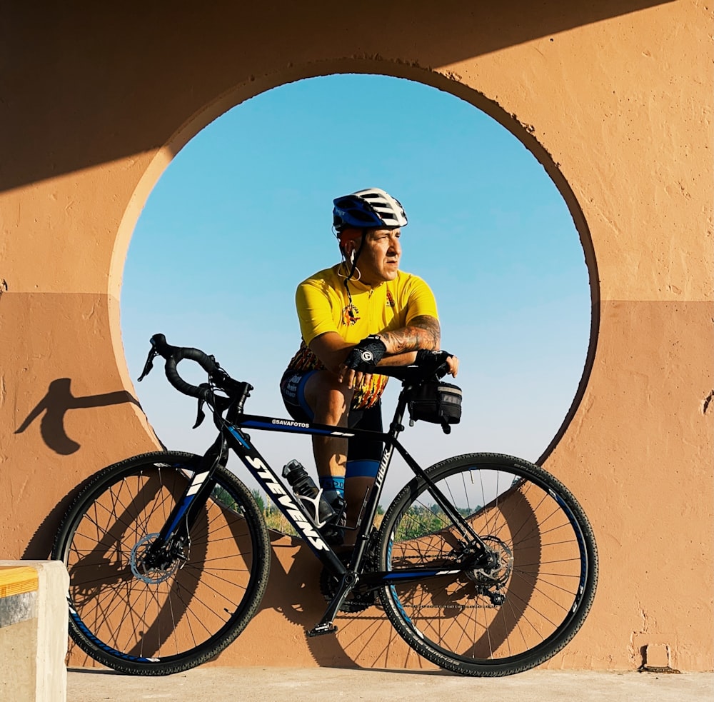 man in green shirt riding black mountain bike