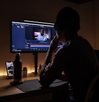 boy in black long sleeve shirt sitting on chair in front of black flat screen tv