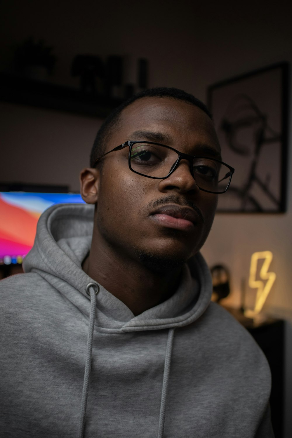 man in gray hoodie wearing black framed eyeglasses