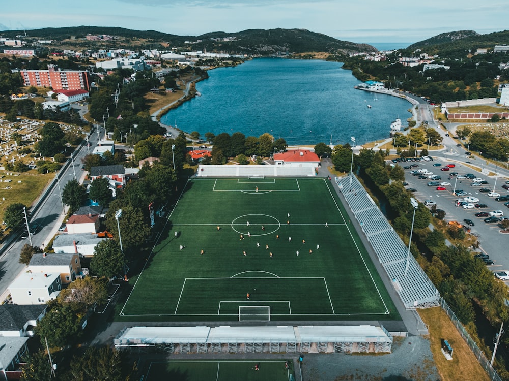 green and white soccer field near body of water during daytime