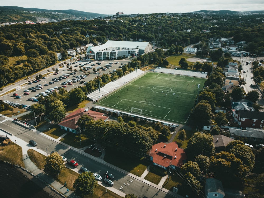 aerial view of green field surrounded by trees during daytime