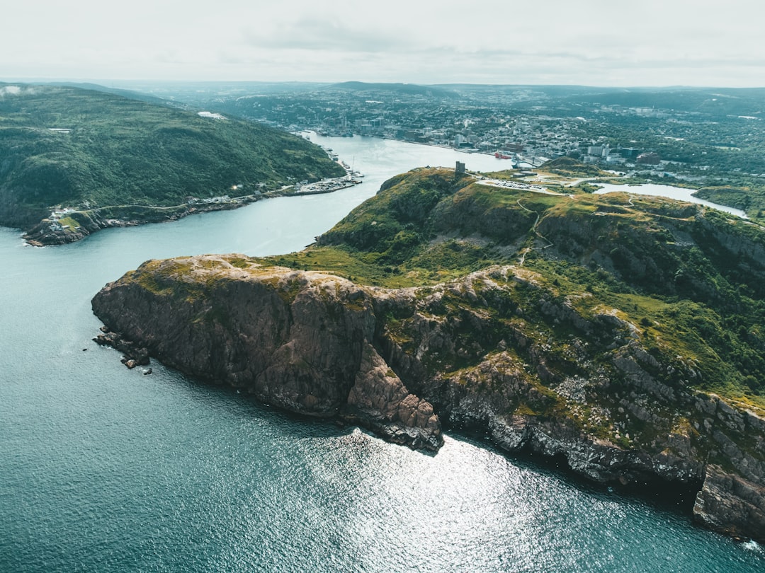 green and brown rock formation on sea during daytime