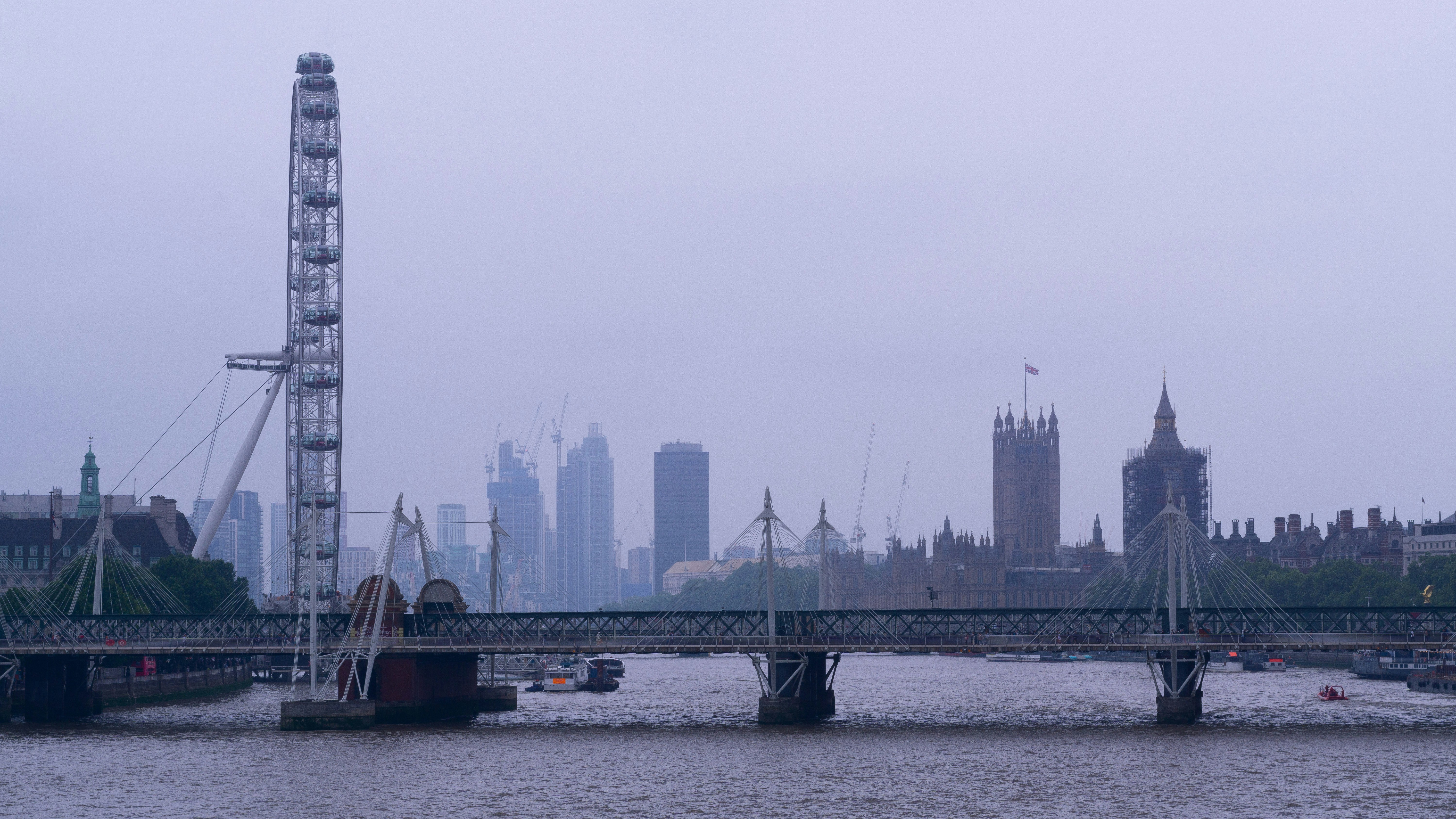 İngiltere'de uzun süreli çalışma vizesi ve yaşam konseptini yansıtan, Londra şehir manzarası önünde profesyonel bir çalışan.