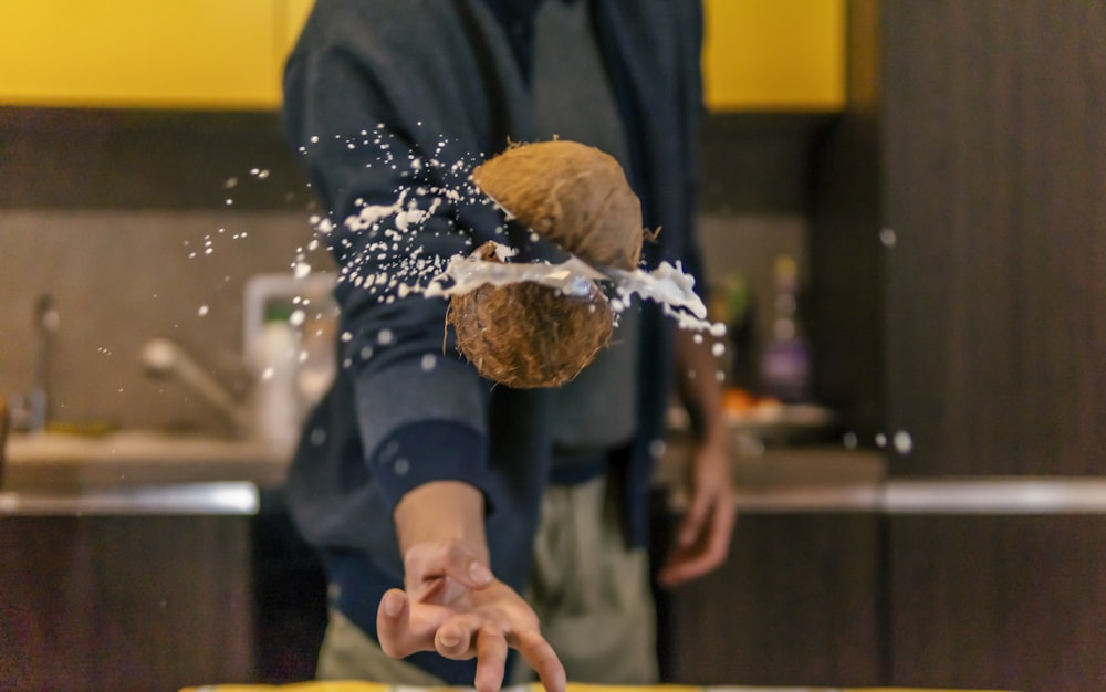 person in black jacket holding brown bread