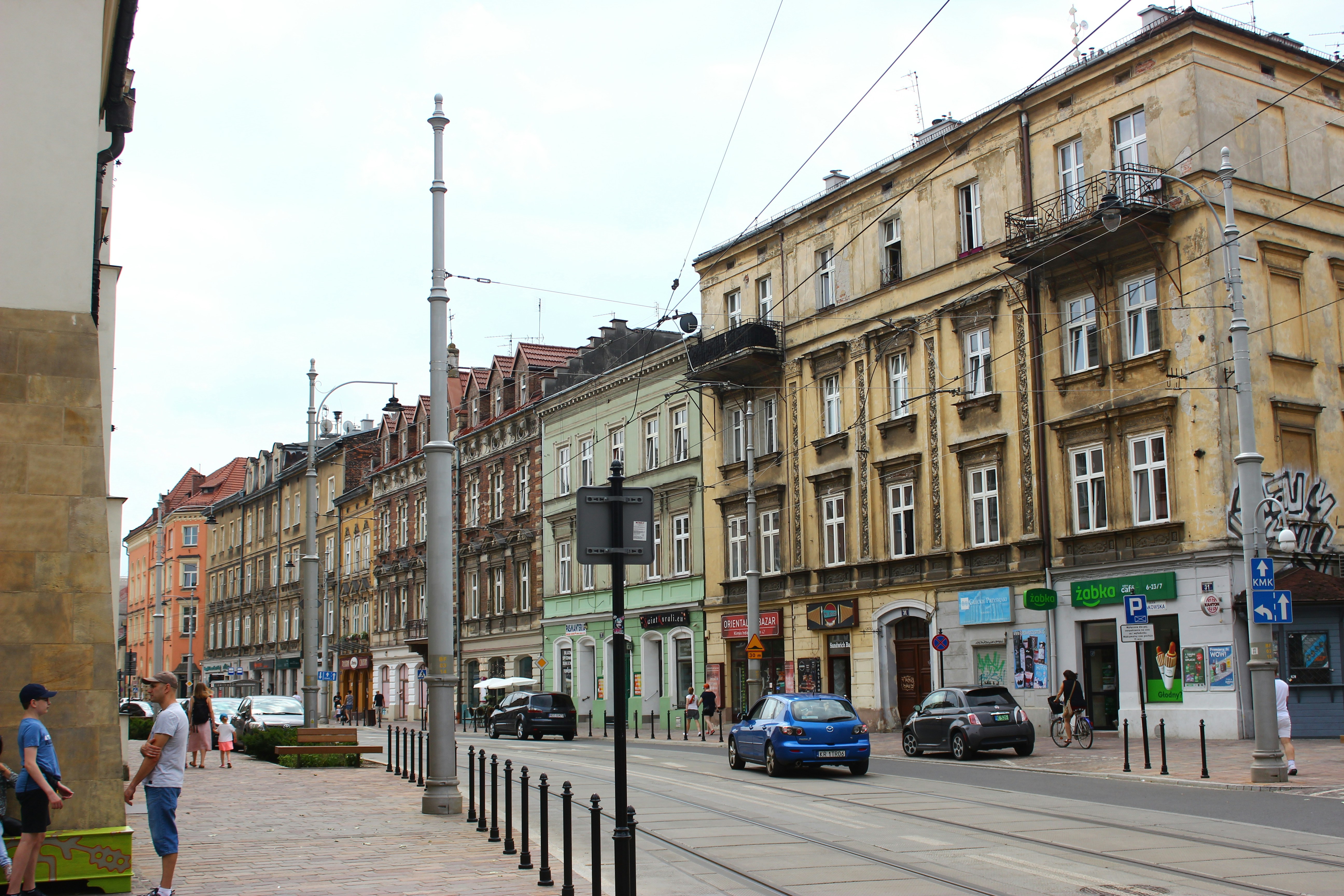 cars parked on sidewalk near building during daytime, Street in Krakow, Poland.