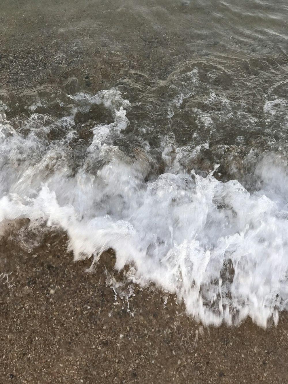 ocean waves crashing on shore during daytime