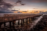 brown wooden dock on sea during sunset