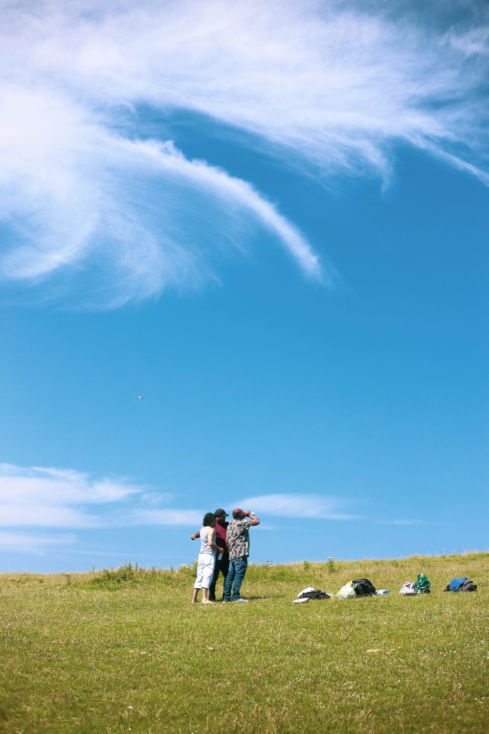 people walking on green grass field under blue sky during daytime