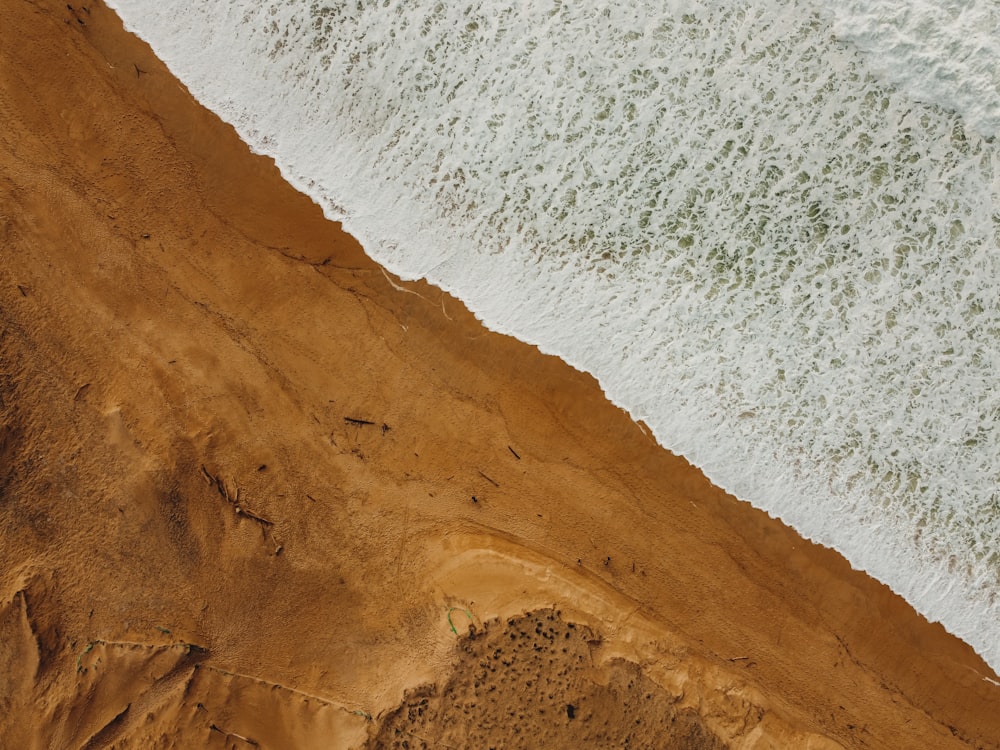 brown sand near body of water during daytime