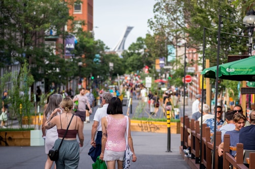 People enjoying outdoor activities in an urban setting with cafes and shops.