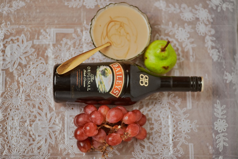 black glass bottle beside green apple fruit