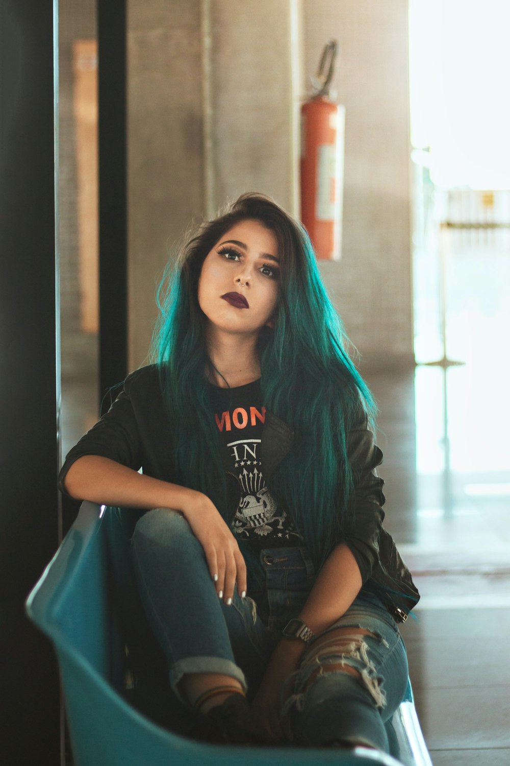 woman in black crew neck t-shirt and blue denim jeans sitting on the floor