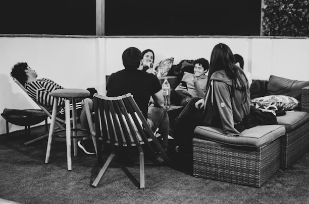 grayscale photo of people sitting on bench