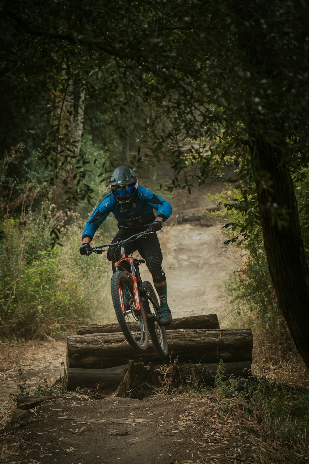 man in blue jacket riding on black mountain bike