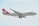 A large cargo airplane with the 'Cargolux' branding is captured mid-flight against a light, slightly cloudy sky. The aircraft has a predominantly white fuselage with a distinct red tail and engines. The branding and company logo are visible, along with the registration code on the side.