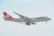 A large cargo airplane with the 'Cargolux' branding is captured mid-flight against a light, slightly cloudy sky. The aircraft has a predominantly white fuselage with a distinct red tail and engines. The branding and company logo are visible, along with the registration code on the side.