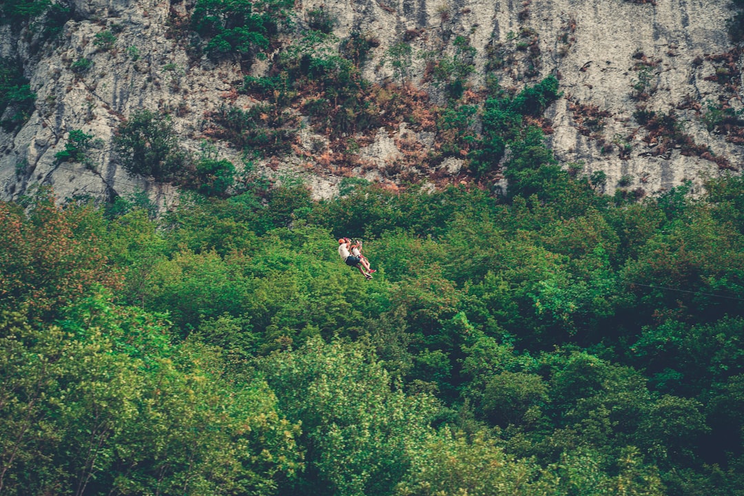 person in black shirt climbing on rocky mountain during daytime