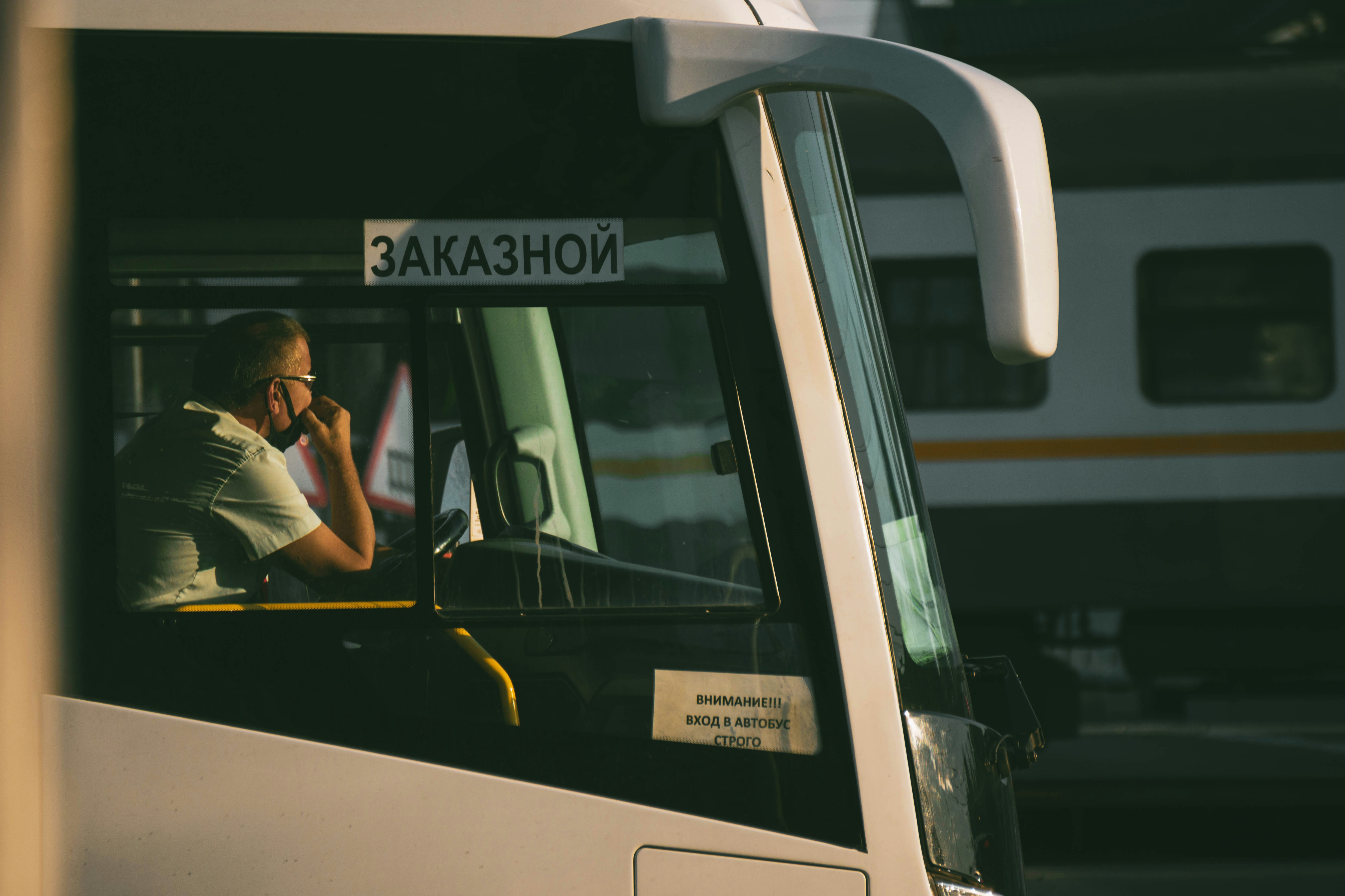 Man in black t-shirt sitting on white bus