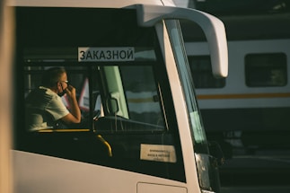man in black t-shirt sitting on white bus