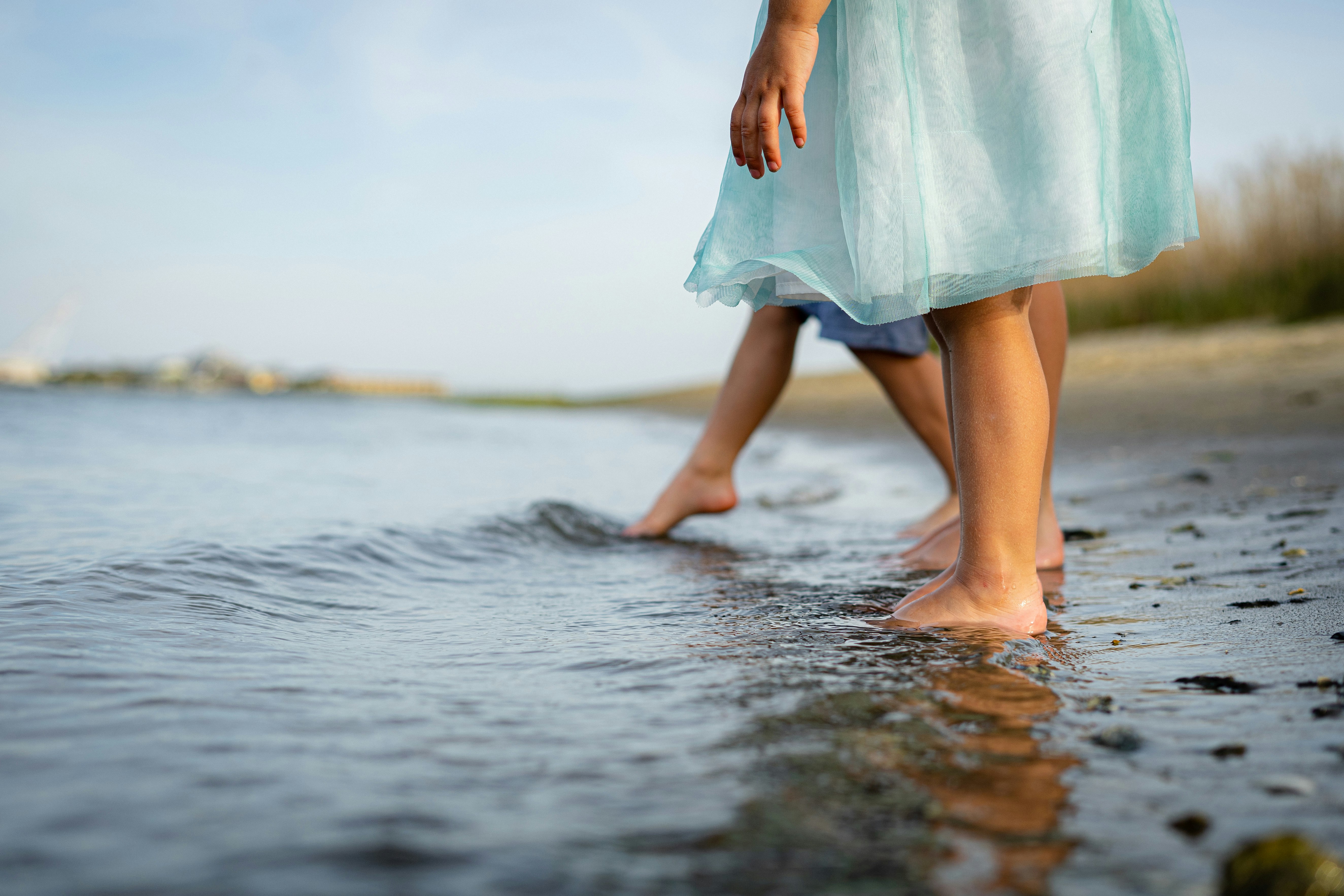 woman in teal dress walking on water