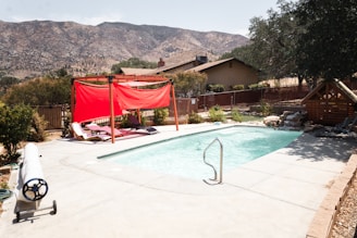red and white textiles hanged on string near swimming pool during daytime