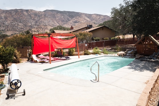 red and white textiles hanged on string near swimming pool during daytime
