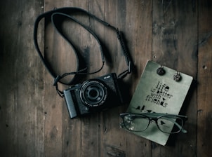 A close-up of a journal and camera resting on a wooden table, ready for the next adventure.