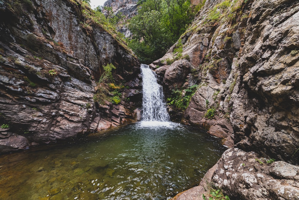 green and brown rocky mountain with water falls