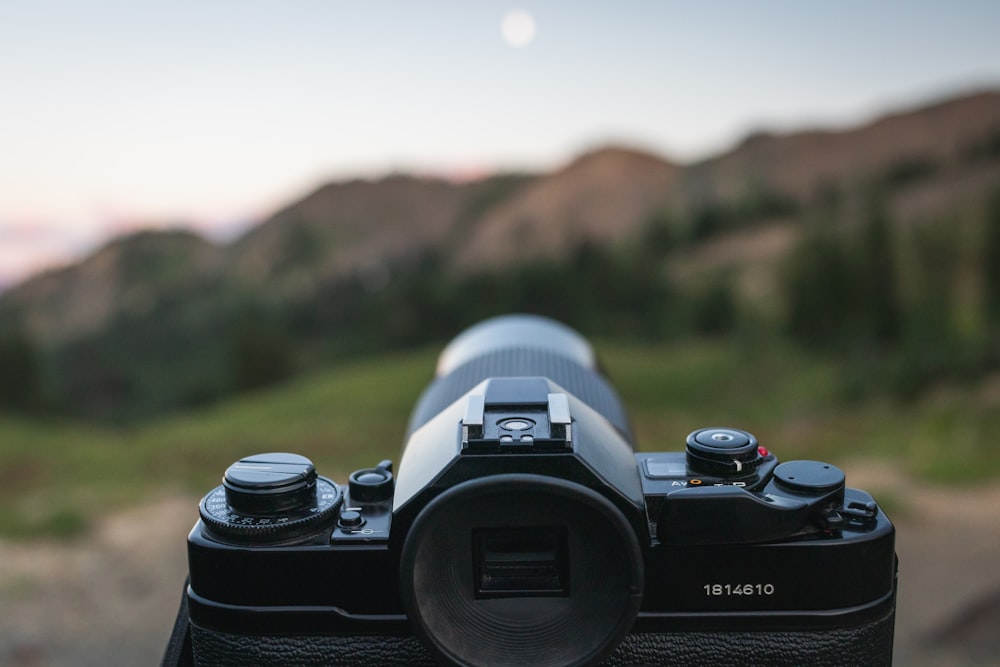 black and white dslr camera on brown wooden table