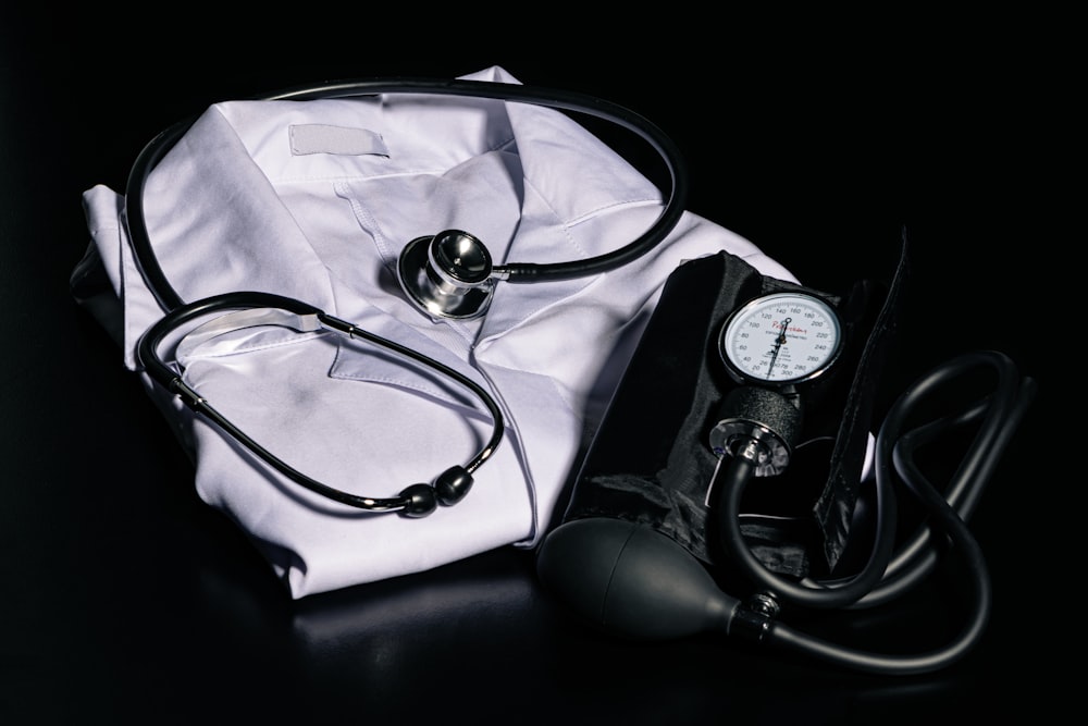 black and silver stethoscope on white textile