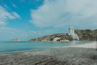 white and black concrete building near body of water under blue sky during daytime