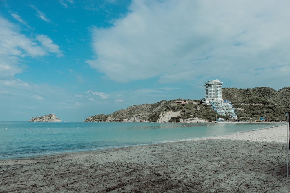 white and black concrete building near body of water under blue sky during daytime