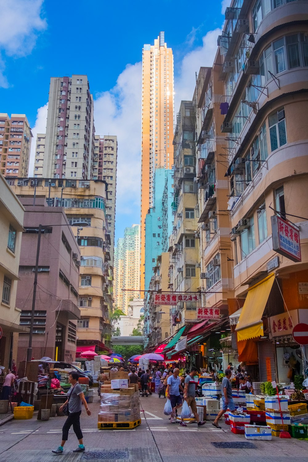 cars parked on street in between high rise buildings during daytime