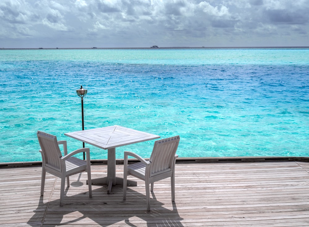 white wooden table and chairs on beach during daytime