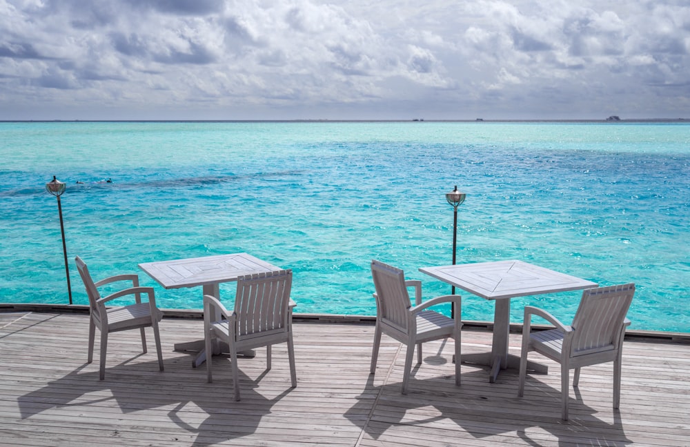 white wooden table and chairs on beach during daytime