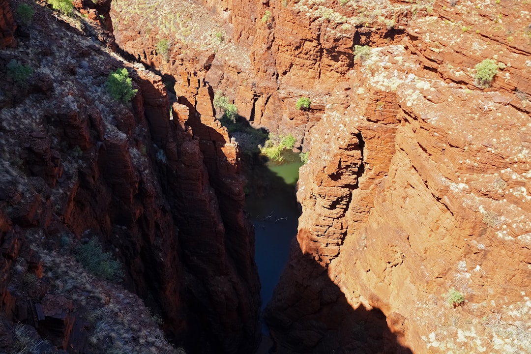 brown rocky mountain beside river during daytime