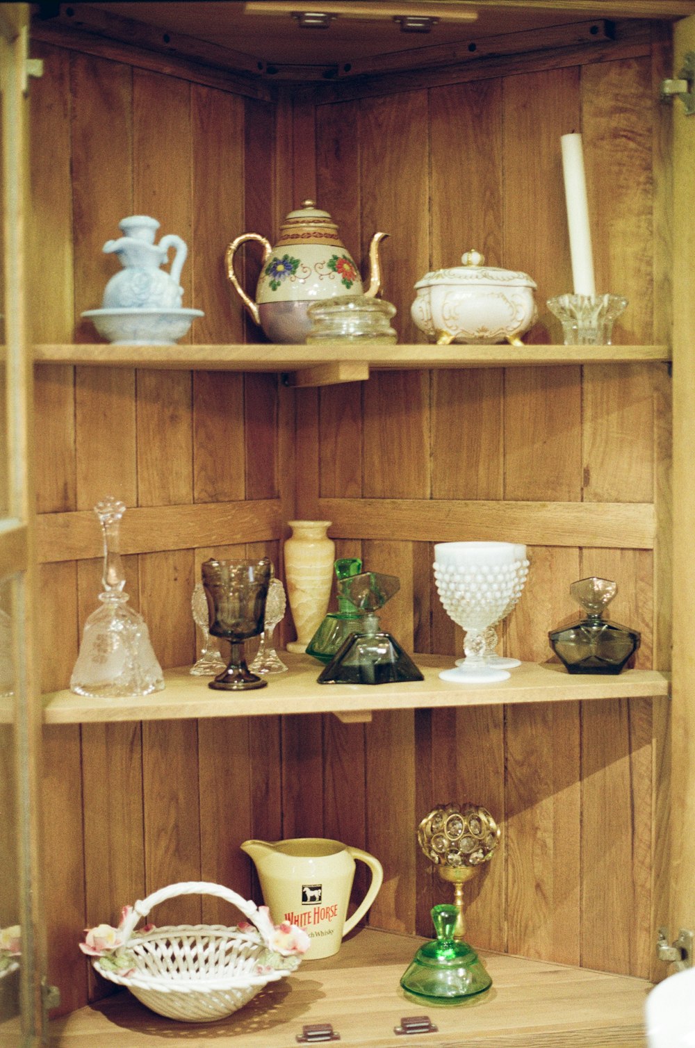 white and blue ceramic tea set on brown wooden shelf