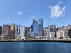 white and blue boat on water near city buildings during daytime