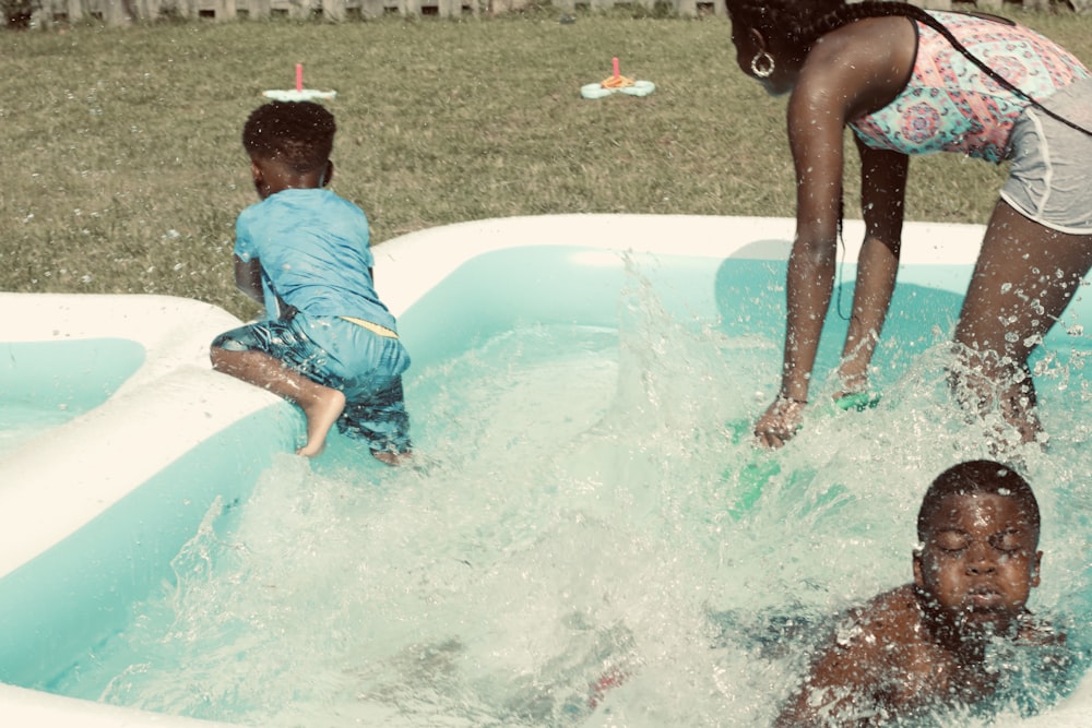 boy in blue t-shirt and black shorts sitting on white ceramic bathtub during daytime