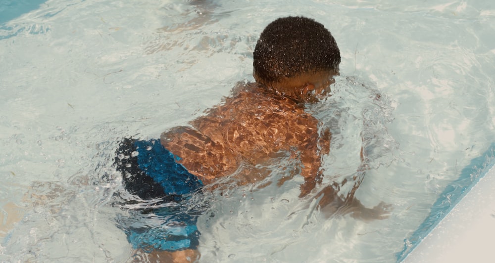 boy in blue shorts on water