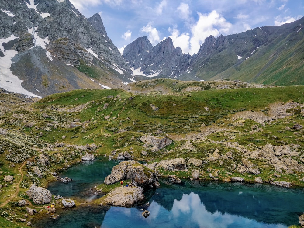 Montañas verdes y grises junto al Lago Azul durante el día