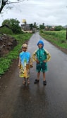 Children playing in colorful raincoats on a rainy day.