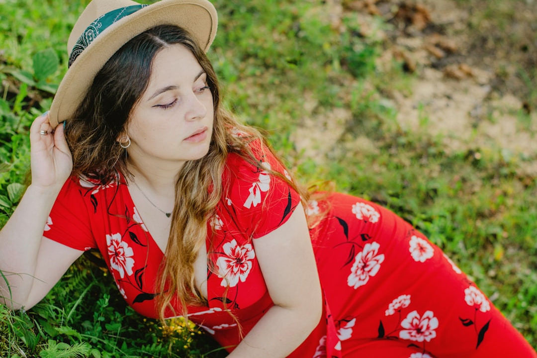 woman in red and white floral dress wearing brown hat